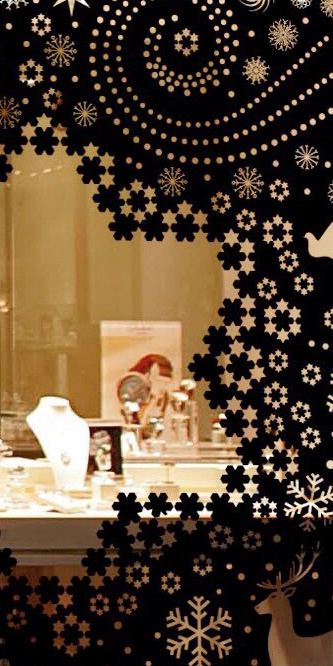 cette photo montre les différents niveaux de lecture du concept, au premier plan un décor de vitrine appelant le public, le chaland à s’approcher pour découvrir tout d’abord les magnifiques objets présentés et pour entrevoir également l’intérieur de la boutique où d’autres belles choses sont à admirer, incitant à entrer. Une fois à l’intérieur, le client peut voir le sapin de Noël éternel en métal découpé comme une dentelle, en digne complément des objets mis en vente dans la boutique d’horlogerie de luxe